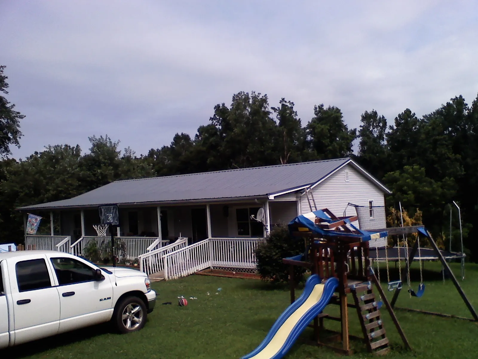 Dark metal roof on a country home with a full length front porch in Dayton