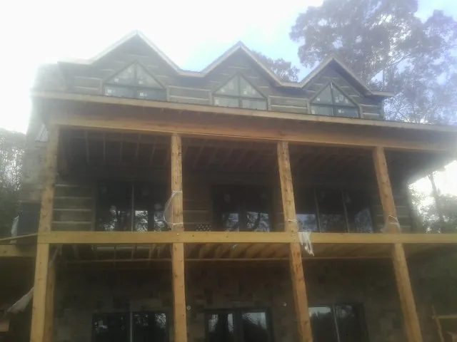 Dormers and porch framing on a large log home under construction — Roof Coating work by our crew in Dayton